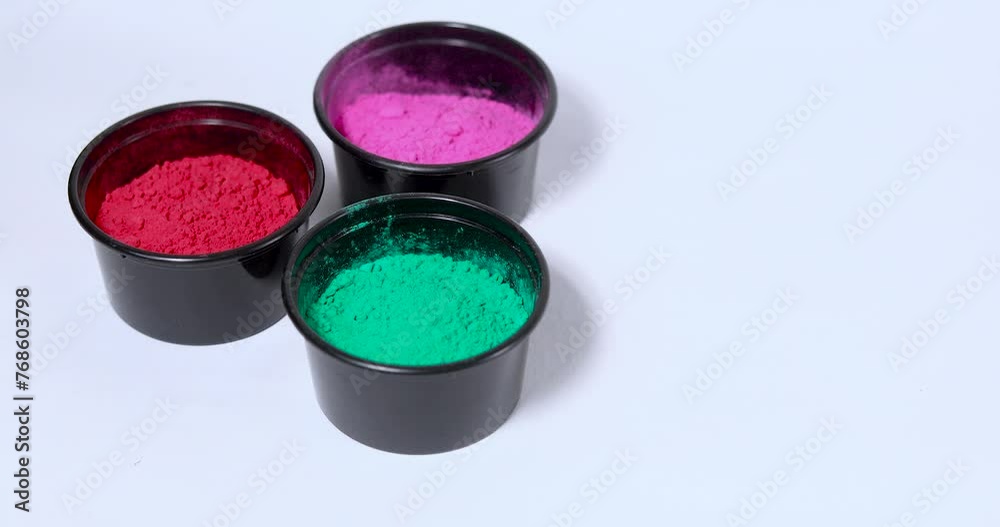 Bowls of different color Holi powder on white surface put by person hand Bowls of different color Holi powder on white surface put by person hand