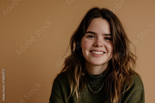 Smiling teen girl with long brown hair in a green sweatshirt © Inigo