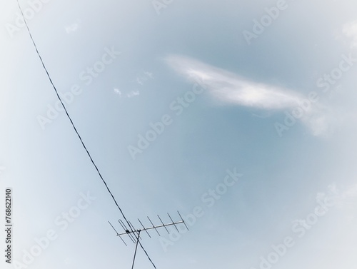 An old TV antenna under blue sky background