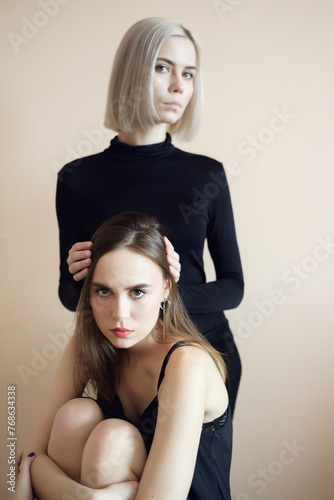 Two young women on a light background.