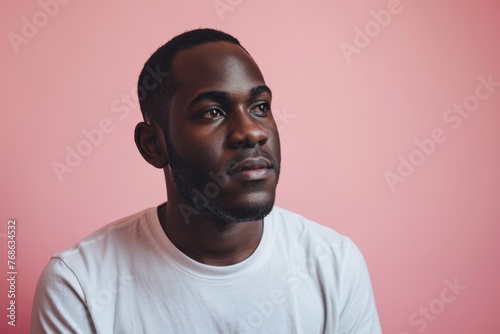 Portrait of young african american man looking away against pink background