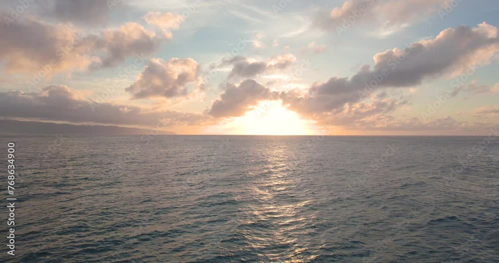 Flying above wavy Pacific ocean toward bright sunset near horizon, Hawaii Flying above wavy Pacific ocean toward bright sunset near horizon, Hawaii