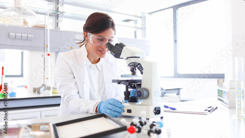 Woman working in a lab and using microscope