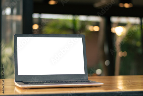 Laptop computer on desk at office or co-working space, Laptop with white blank on screen and blurred background , working space concept.