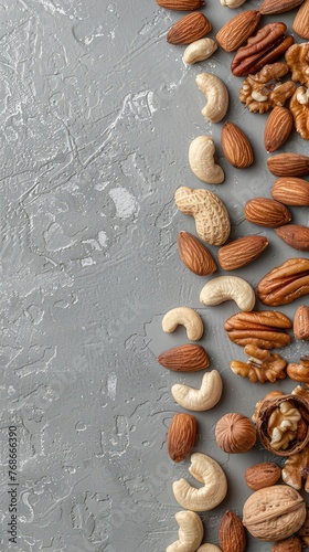 nuts and seeds meticulously arranged on a sleek gray background, with a prominent copy space banner, perfect for food-related concepts or presentations.