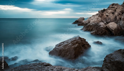 Beautiful sea view with rocks, blue sky and calm water. Long exposure photography.