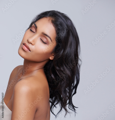 Woman, hair and texture for beauty with eyes closed, salon treatment for growth and cosmetics on grey background. Face, haircare and shine with calm, cosmetology and change with hairstyle in studio