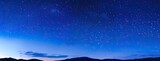 a panoramic night sky adorned with twinkling stars against a deep blue backdrop, perfect for creating a captivating starry background or celestial-themed banner.