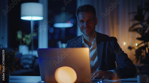 Businessman working on laptop computer late at night in office.