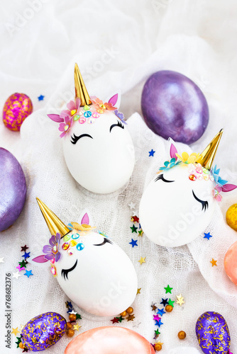 Easter eggs in the form of a unicorn on white background, copy space for text, top view, flat lay
