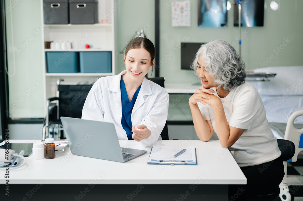 Obraz premium Doctor discussing treatment with male patient talking and laughing sitting on examination bed in clinic or hospital.