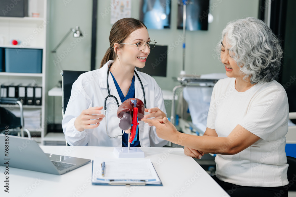 Doctor in white suit take notes while discussing and Asian elderly, man patient who lying on bed with receiving saline solution Doctor in white suit take notes while discussing and Asian elderly, man patient who lying on bed with receiving saline solution