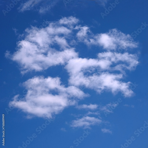 Beautiful celestial landscape with white clouds in blue sky on a sunny summer day on square photo