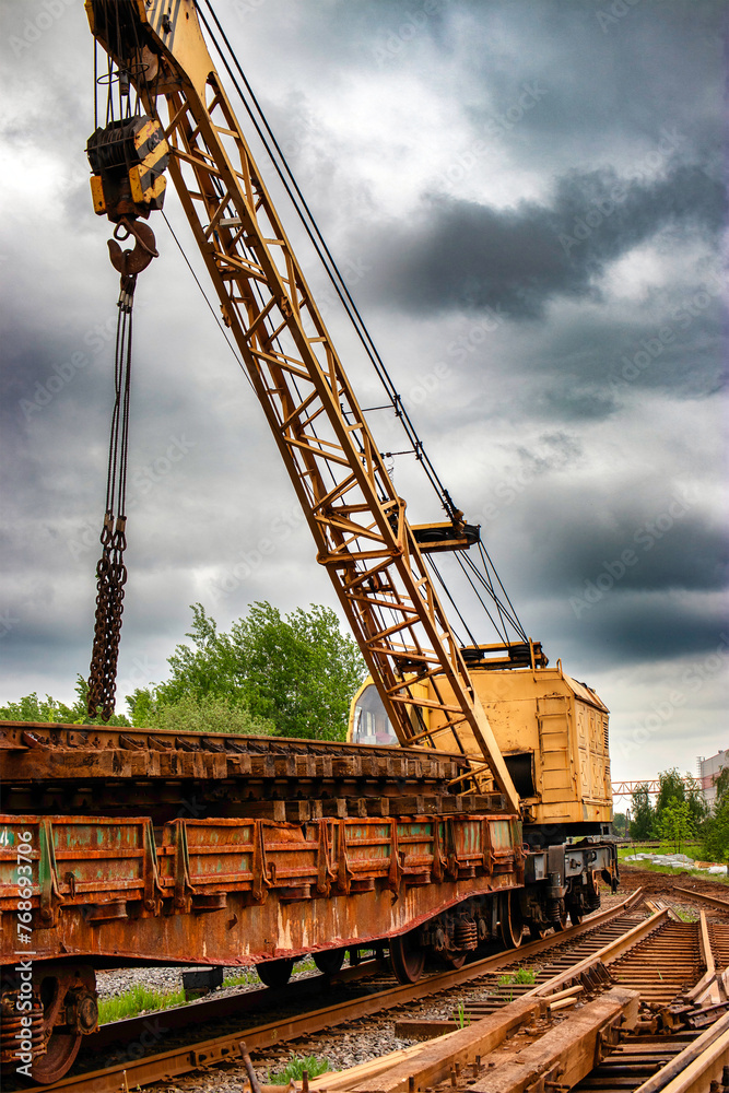 A large crane is standing on top of a railway track, potentially in the process of construction or repair work