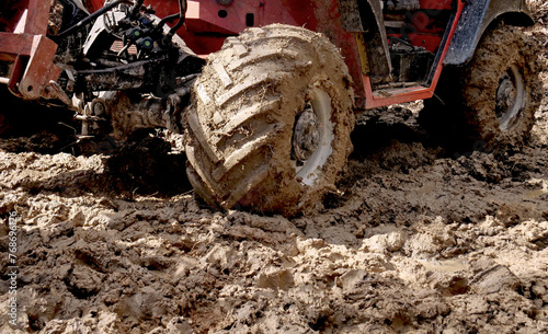 The wheels of an agricultural tractor full of mud on a country road