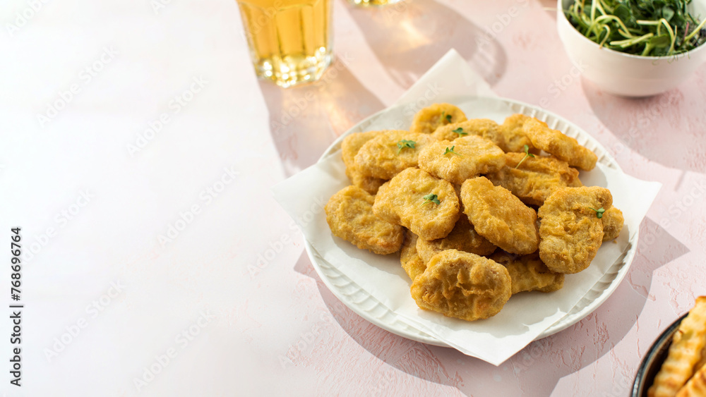 Delicious golden chicken nuggets on a plate on the table. Fast food, menu. Copy space Delicious golden chicken nuggets on a plate on the table. Fast food, menu. Copy space