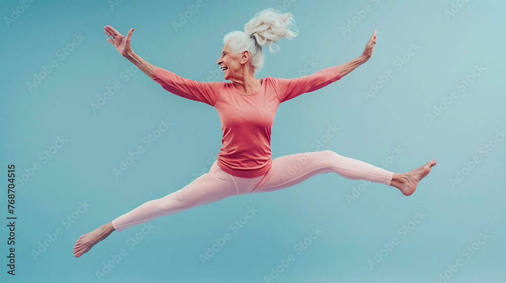 Fototapeta premium Сheerful elderly woman in yoga suit jumping in the air