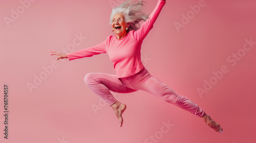 Сheerful elderly woman in yoga suit jumping in the air
