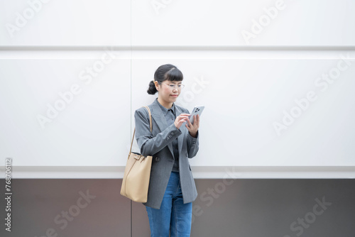 Office woman looking at mobile phone in subway station