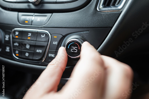 The hand regulates the temperature in the car interior. Air conditioner control