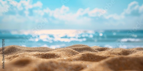 A photo of an empty sandy beach with the ocean in the background, blue sky, blurred bokeh effect, closeup shot.
