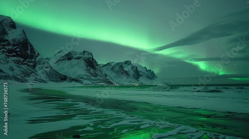 Aurora dancing above snowy mountains, illuminating Skagsanden Beach, Lofoten Islands