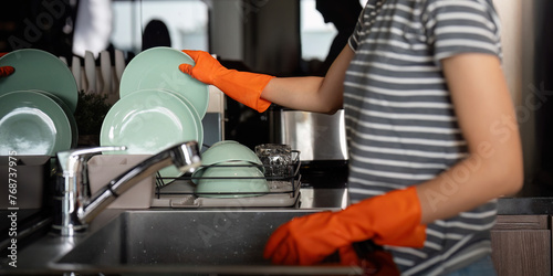 Woman washing up at home dishes in sink