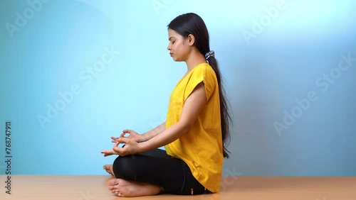 Beautiful woman practicing Siddhasana, also known as Accomplished pose or Perfect pose yoga, isolated indoor home background photo