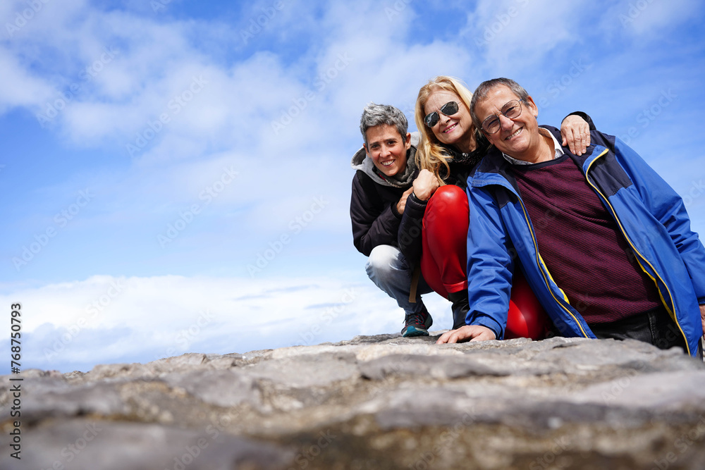 A family posing for a picture on a rocky hill. Scene is happy and tender