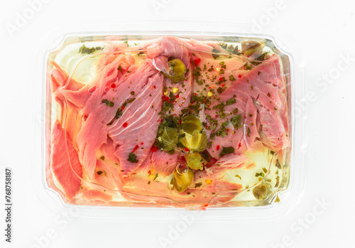 tuna carpaccio with capers in a package on white