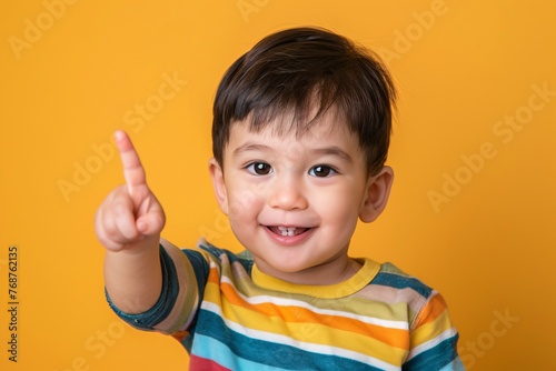 a child pointing up with his finger