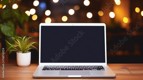 Laptop with blank screen on wooden table in coffee shop,