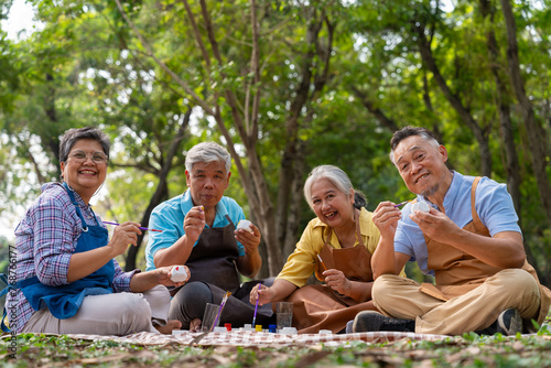 A group of Asian senior people enjoy painting cactus pots and recreational activity or therapy outdoors together  at an elderly healthcare center, Lifestyle concepts about seniority © Prot