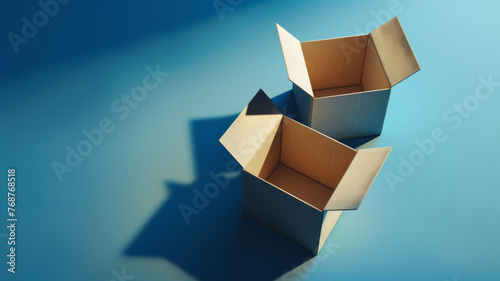 Two open cardboard boxes cast sharp shadows on a plain blue background, hinting at relocation.