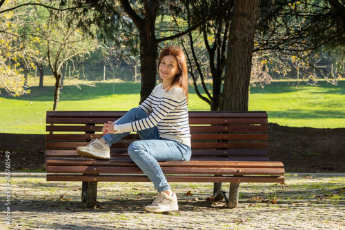 A woman is sitting on a park bench