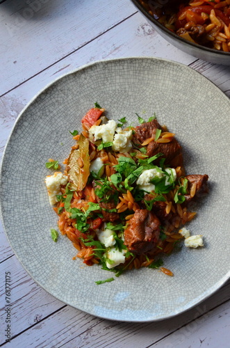 lamb stewed with tomatoes and orzo, background of greek traditional food youvetsi photo