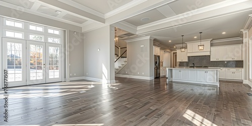 Luxurious New Home Featuring a Spacious Living Room with Hardwood Floors, Vaulted Ceiling, and Kitchen Entryway View. Concept Luxury Home, Spacious Living Room, Hardwood Floors, Vaulted Ceiling