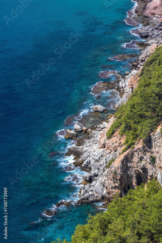 Alanya coast, Turkey (Turkiye). Cliffside and crystal waters along the shore, capturing the interplay of sea and rugged terrain. Vertical nature cover page or wallpaper