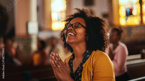 Mulher afro orando alegremente na igreja photo
