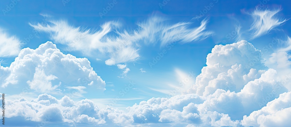 White voluminous cumulus clouds hang in the blue sky above a peaceful body of water, creating a serene and picturesque scene White voluminous cumulus clouds hang in the blue sky above a peaceful body of water, creating a serene and picturesque scene