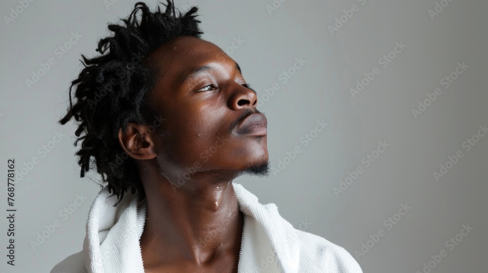 Obraz premium A man with curly hair looking up with a contemplative expression wearing a white robe.