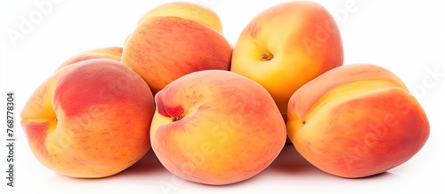 Arrangement of five ripe peaches neatly stacked on a clean white surface, showcasing their vibrant color and fresh appearance