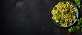 Freshly cooked Vegan Farfalle pasta covered in a creamy spinach sauce, served with nutritious broccoli, brussels sprouts, and green beans on a stylish dark stone plate