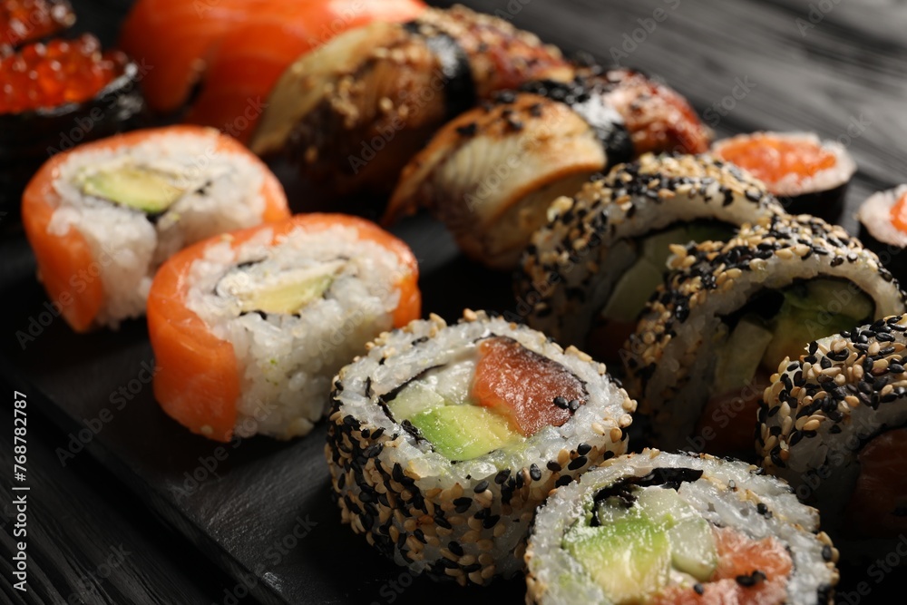 Set of delicious sushi rolls on black wooden table, closeup Set of delicious sushi rolls on black wooden table, closeup