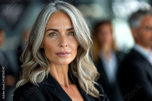 Captivating Grey-Haired Businesswoman Stands Out Amongst Business Professionals photo
