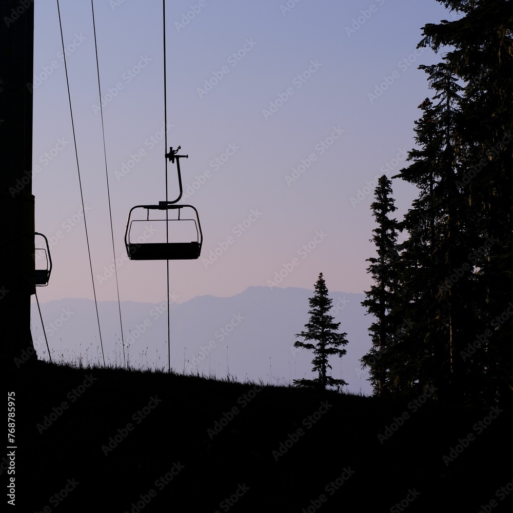 Ski lift chairlift against the backdrop mountain, surrounded by lush evergreen trees Ski lift chairlift against the backdrop mountain, surrounded by lush evergreen trees