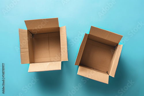 Two empty cardboard boxes open against a solid blue background.