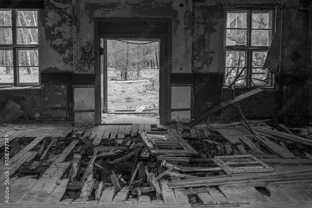 Greyscale of an abandoned interior space with a blackened, decrepit aesthetic