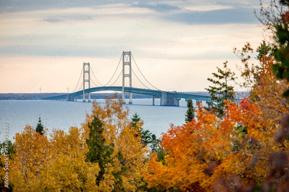 Aerial view of the Mackinac Bridge in Michigan, surrounded by vibrant fall colors of the forests