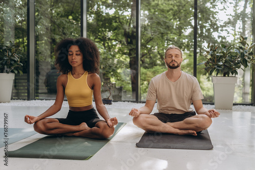 Woman and man sitting in lotus pose on regulary meditation training photo